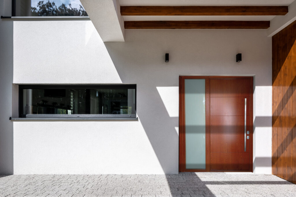 Exterior of elegant house with white facade, stylish doors, long window and wooden decorations
